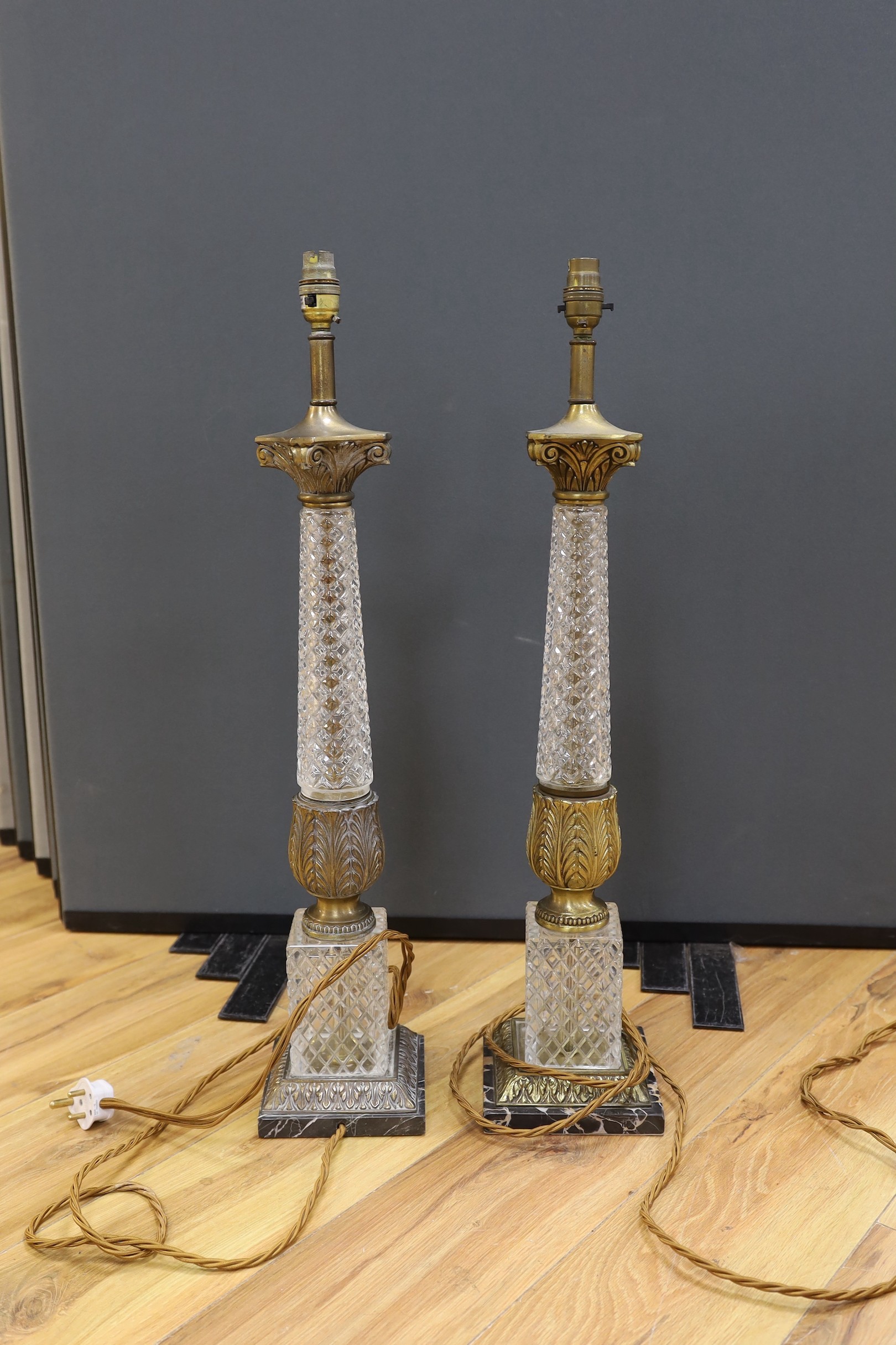 A pair of gilt brass and glass lamps with shades, 71cms high including light fitting